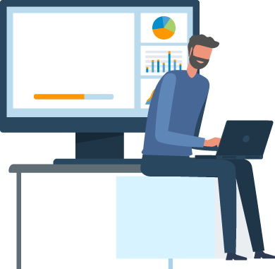 A man sits on a desk, working on a laptop while looking at a large monitor displaying charts and data.